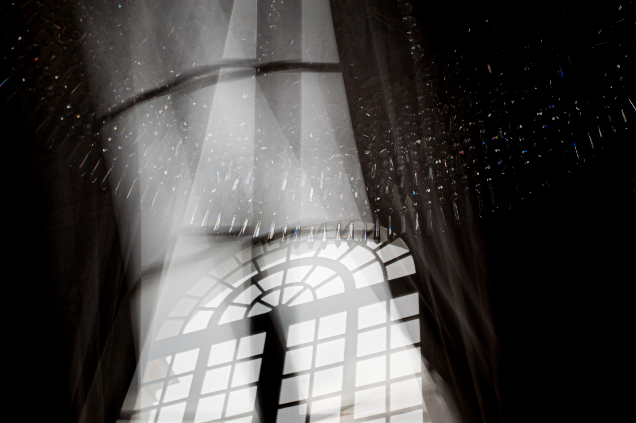 Zwart-witfoto in kasteel van een raam en kroonluchter en licht - foto van Lisette Geel